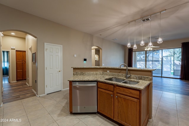 kitchen with dishwasher, sink, decorative light fixtures, a kitchen island with sink, and light wood-type flooring