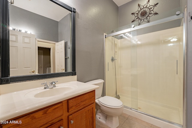 bathroom with tile patterned flooring, toilet, an enclosed shower, and vanity