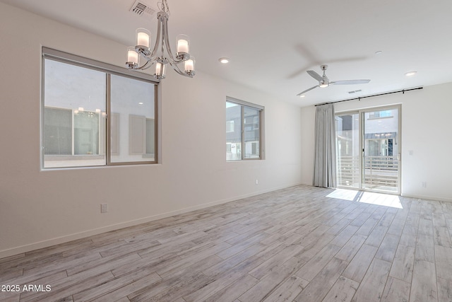 unfurnished room with light wood-style floors, visible vents, baseboards, and ceiling fan with notable chandelier