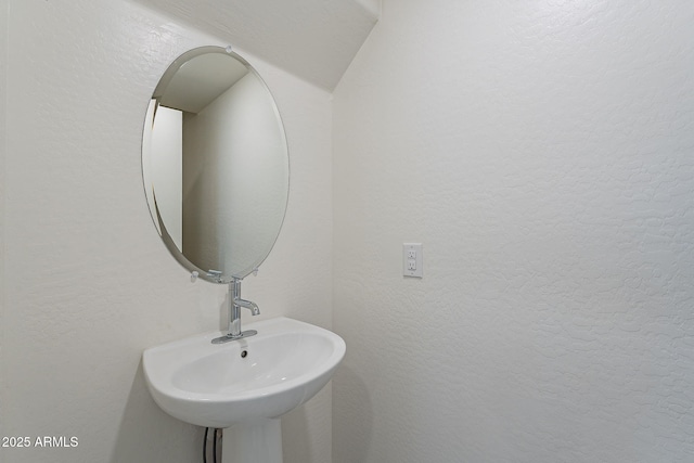 bathroom with a sink and a textured wall