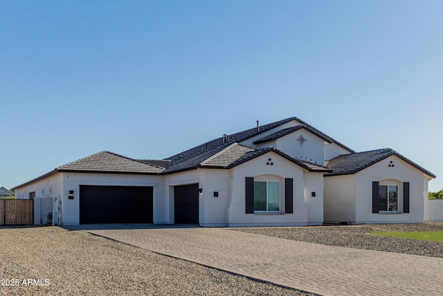 single story home featuring a tile roof, driveway, fence, a garage, and stucco siding