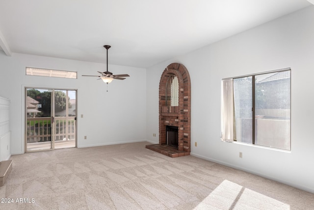 unfurnished living room featuring light carpet, a fireplace, and ceiling fan