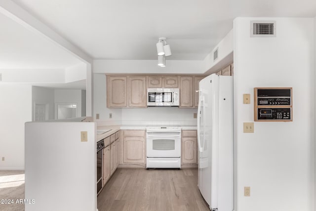 kitchen featuring light wood-type flooring, light brown cabinetry, and white appliances