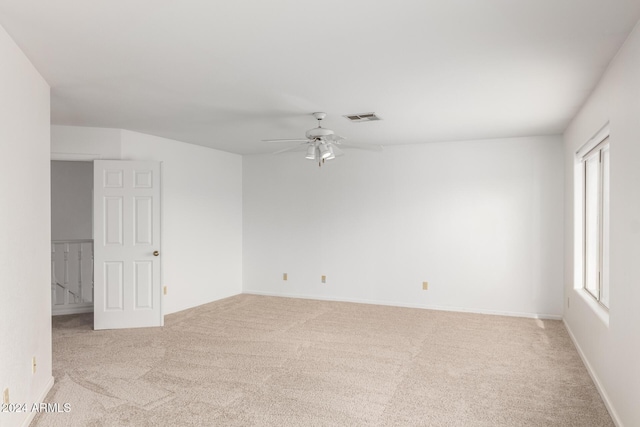 unfurnished room featuring light colored carpet, plenty of natural light, and ceiling fan