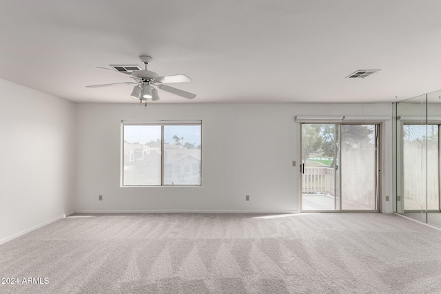 empty room with light colored carpet and a healthy amount of sunlight