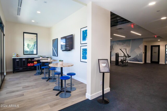 interior space featuring a drop ceiling and light wood-type flooring