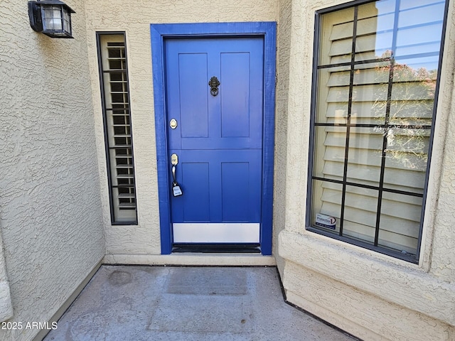 property entrance with stucco siding