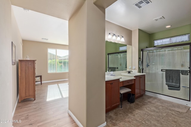 bathroom with hardwood / wood-style floors, vanity, and a shower with door