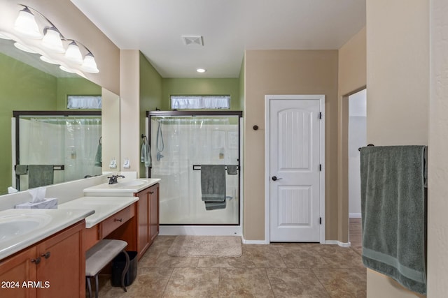 bathroom featuring tile patterned flooring, vanity, and a shower with shower door