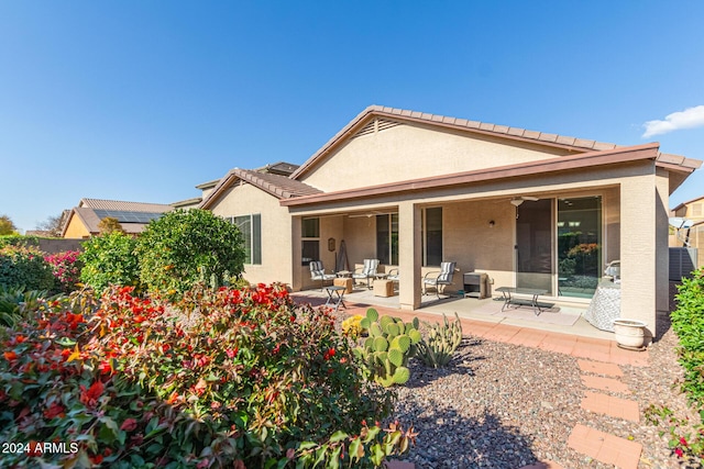 back of property featuring ceiling fan and a patio