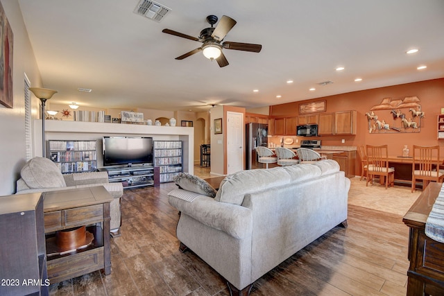 living room with hardwood / wood-style floors and ceiling fan