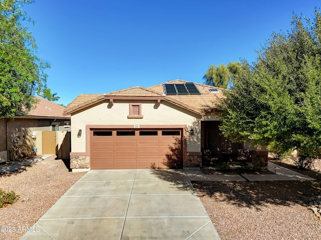 view of front of property featuring a garage and solar panels