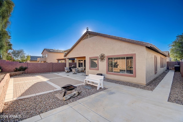 rear view of property with a fire pit and a patio area