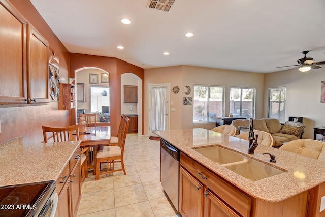 kitchen with a kitchen island with sink, sink, ceiling fan, light stone countertops, and stainless steel appliances