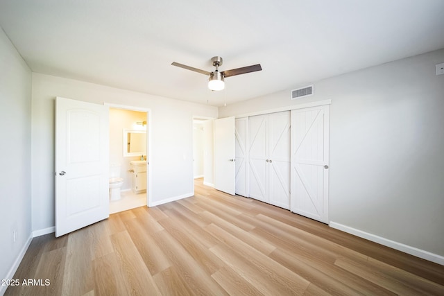 unfurnished bedroom with visible vents, baseboards, ensuite bathroom, light wood-style floors, and a closet