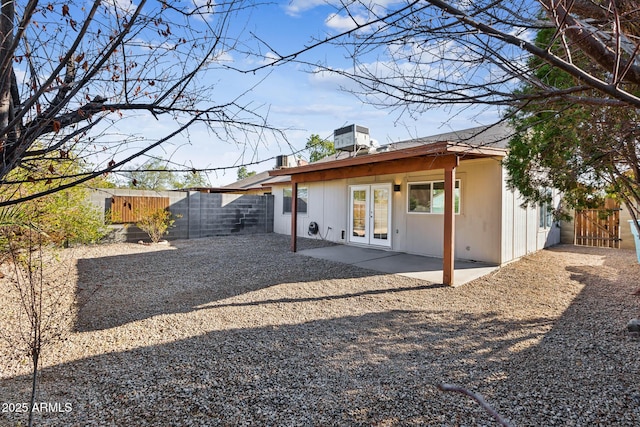 rear view of property featuring a fenced backyard, french doors, a patio, and a gate