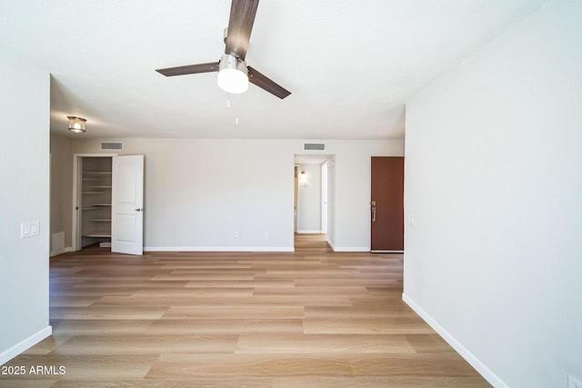 unfurnished room with a ceiling fan, baseboards, visible vents, and light wood finished floors