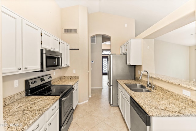 662 S Saddle St, Gilbert, AZ 85233 - kitchen with stainless steel appliances, a sink, arched walkways, white cabinets, and light stone countertops