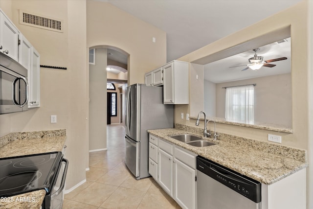 662 S Saddle St, Gilbert, AZ 85233 - kitchen featuring appliances with stainless steel finishes, a sink, a ceiling fan, arched walkways, and light tile patterned floors