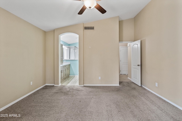 662 S Saddle St, Gilbert, AZ 85233 - unfurnished bedroom featuring carpet flooring, arched walkways, ensuite bath, baseboards, and a ceiling fan