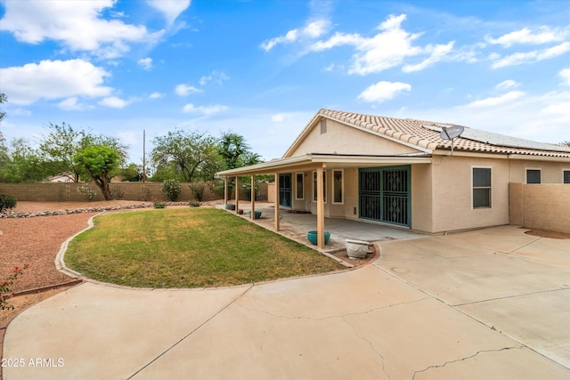 662 S Saddle St, Gilbert, AZ 85233 - back of property with stucco siding, a patio area, a tiled roof, and solar panels