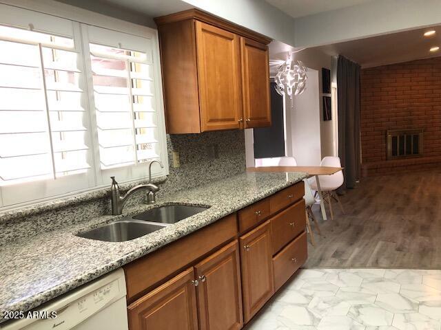1156 E Vinedo Ln, Tempe, AZ 85284 - kitchen featuring a sink, dishwasher, light stone counters, brown cabinetry, and light marble finish flooring