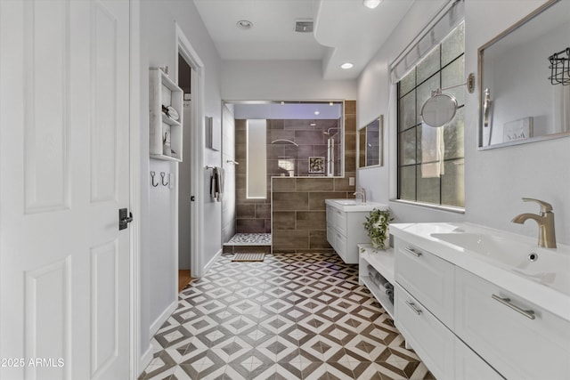 bathroom featuring a tile shower and vanity