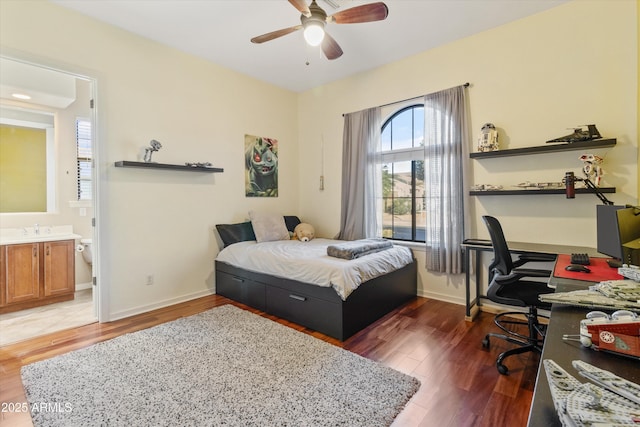 bedroom featuring ceiling fan, sink, dark hardwood / wood-style floors, and ensuite bathroom