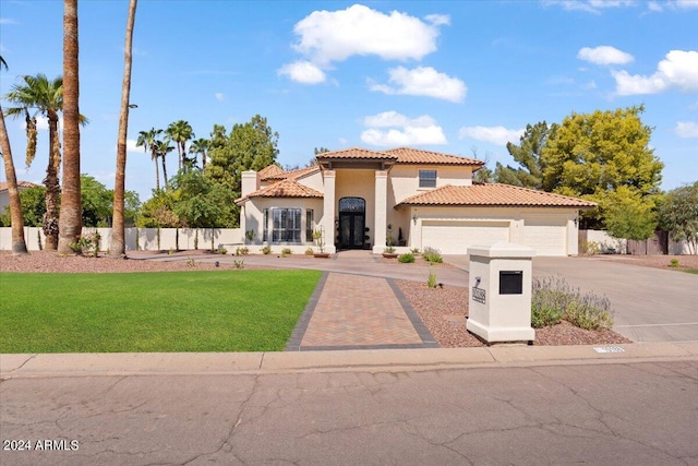 mediterranean / spanish-style house featuring a front yard and a garage