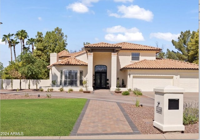 mediterranean / spanish home with a garage and a front yard