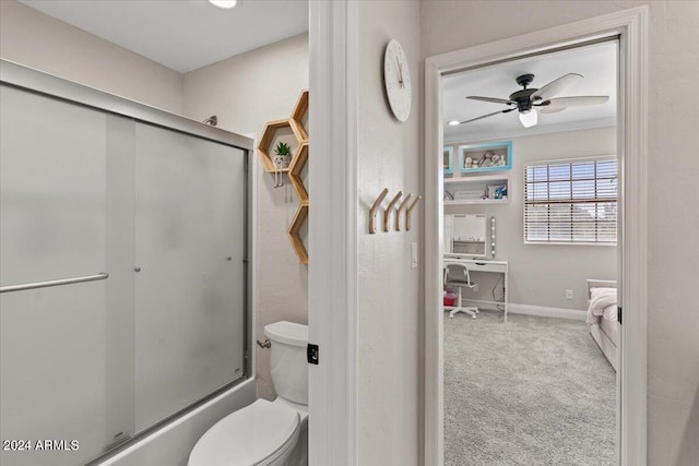 bathroom with enclosed tub / shower combo, toilet, and ceiling fan