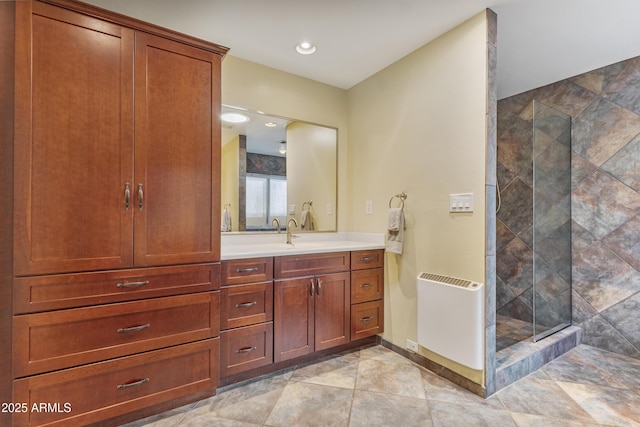 full bath featuring baseboards, radiator heating unit, vanity, a shower stall, and recessed lighting