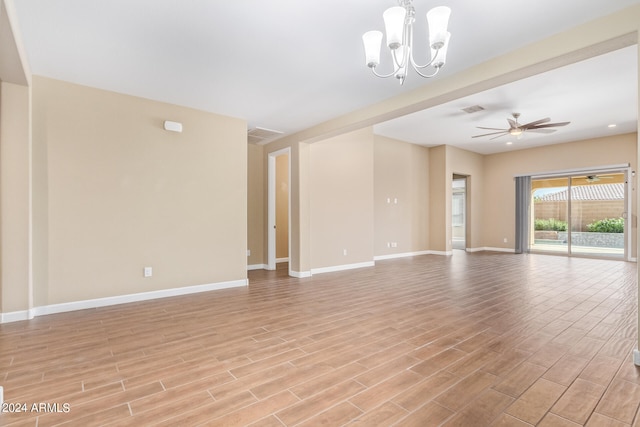 spare room featuring ceiling fan with notable chandelier and light hardwood / wood-style flooring