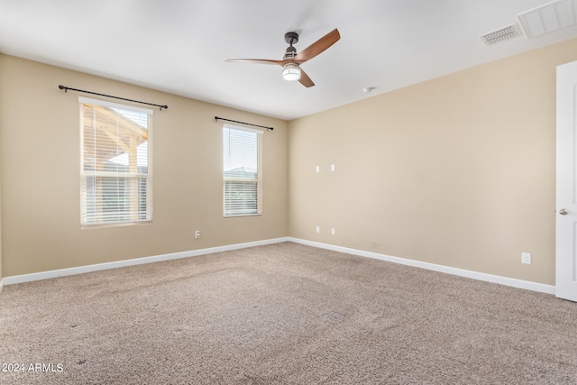 carpeted spare room featuring ceiling fan