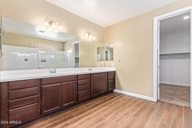 bathroom featuring hardwood / wood-style flooring, walk in shower, and vanity