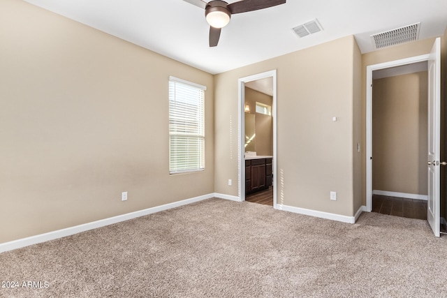 unfurnished bedroom with carpet flooring, ensuite bath, and ceiling fan