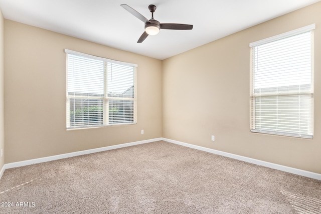 empty room featuring a healthy amount of sunlight, carpet flooring, and ceiling fan