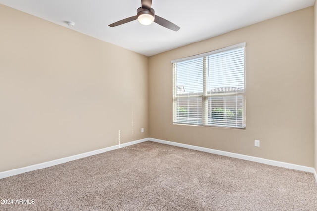 carpeted spare room featuring ceiling fan