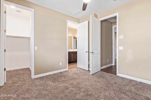 unfurnished bedroom featuring carpet, ceiling fan, ensuite bathroom, and a closet