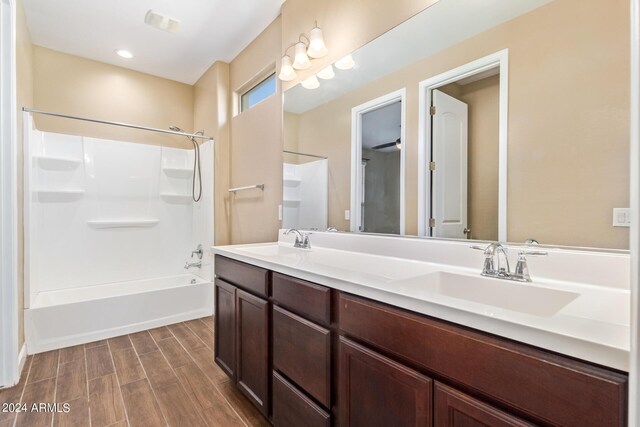 bathroom featuring wood-type flooring, shower / bathing tub combination, and vanity