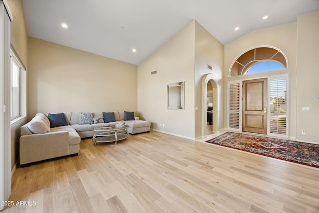11816 E Terra Dr, Scottsdale, AZ 85259 - living room with wood finished floors, high vaulted ceiling, arched walkways, and recessed lighting