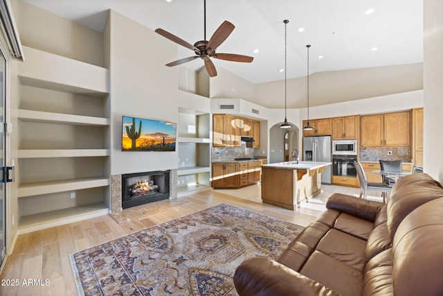 11816 E Terra Dr, Scottsdale, AZ 85259 - living area featuring ceiling fan, a high end fireplace, built in features, recessed lighting, and light wood-style floors