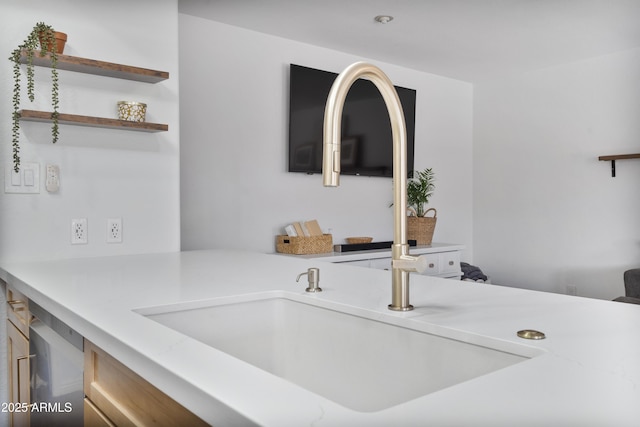 kitchen featuring light countertops, open shelves, and a sink