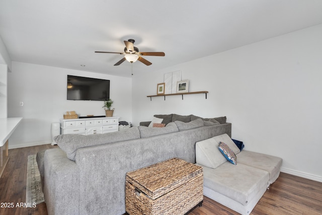 living room with baseboards, ceiling fan, and dark wood-style flooring