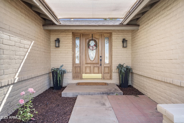 property entrance with brick siding and roof with shingles