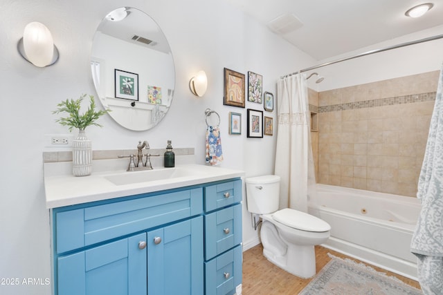 bathroom with vanity, wood finished floors, visible vents, toilet, and shower / tub combo with curtain