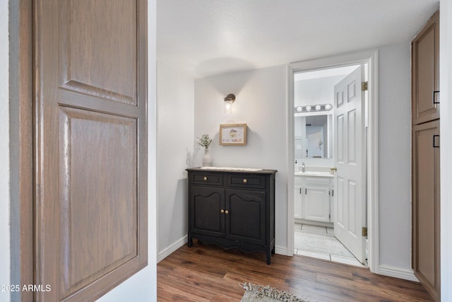 bathroom featuring vanity, baseboards, and wood finished floors