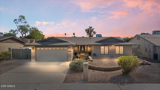 ranch-style house with concrete driveway, an attached garage, and brick siding