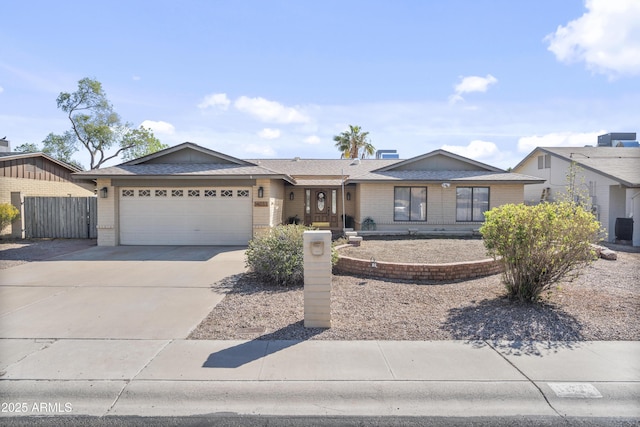 single story home featuring concrete driveway, an attached garage, fence, and brick siding