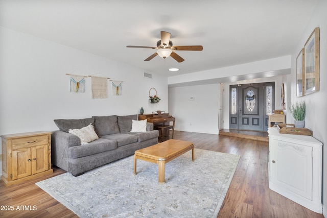 living room featuring ceiling fan, visible vents, and wood finished floors